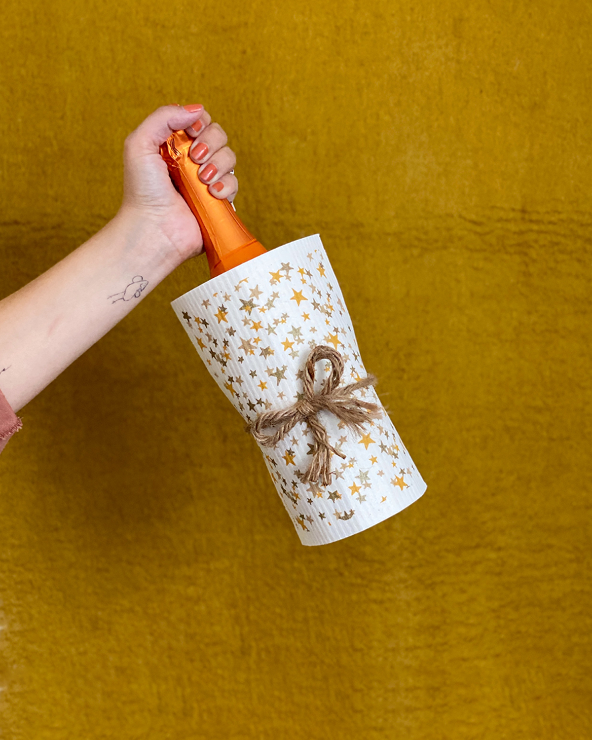 A bottle of wine wrapped in a Ten and Co. Starry Night Sponge Cloth.