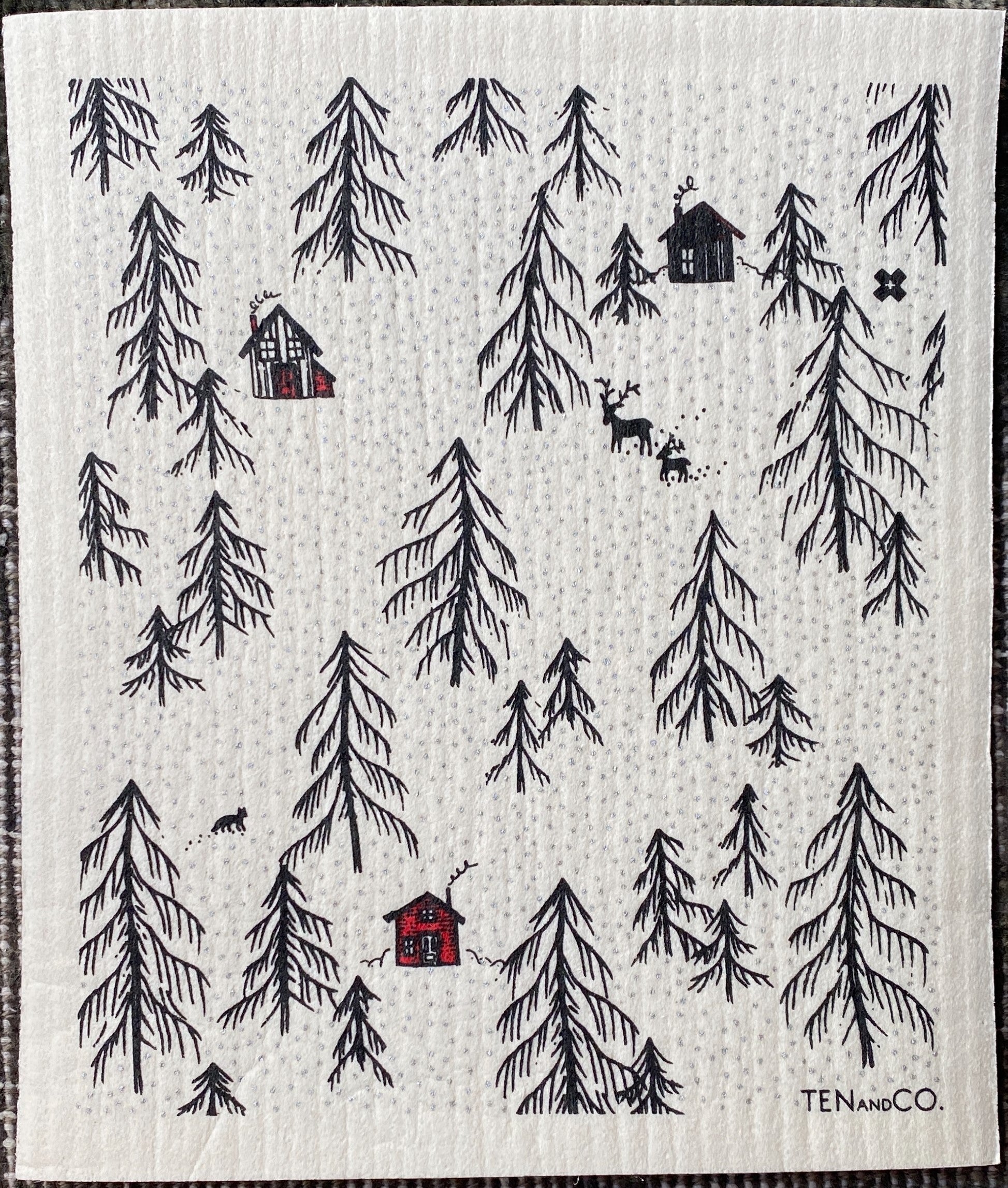 Three black and red houses surrounded by black pine trees with deer and fox in scene.