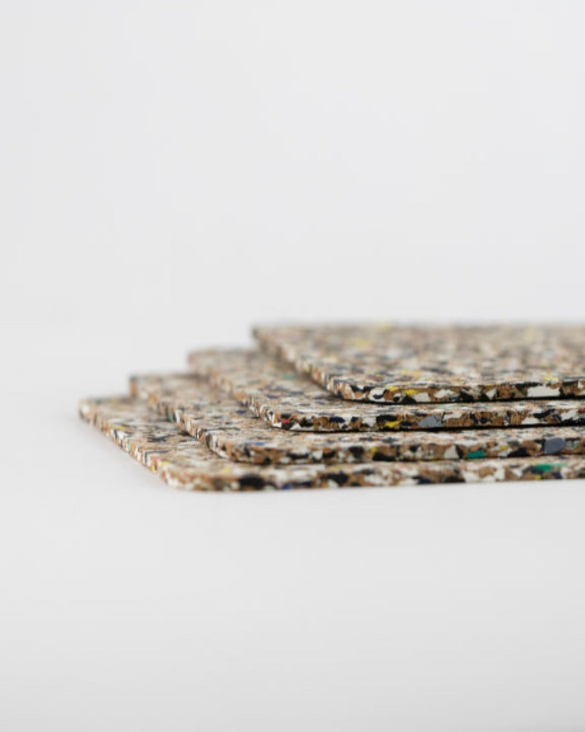 Product image of Beach Clean Coasters on a white background. You can see the side of 4 square coasters, stacked with some space between them.    