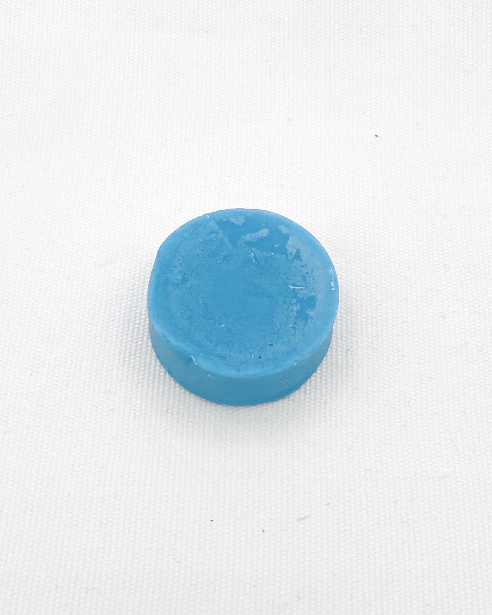 Product image of For Tangles Conditioner Bar on a white background. The bar is a cylinder and is a light blue colour. It is 2 inches by 2 inches.