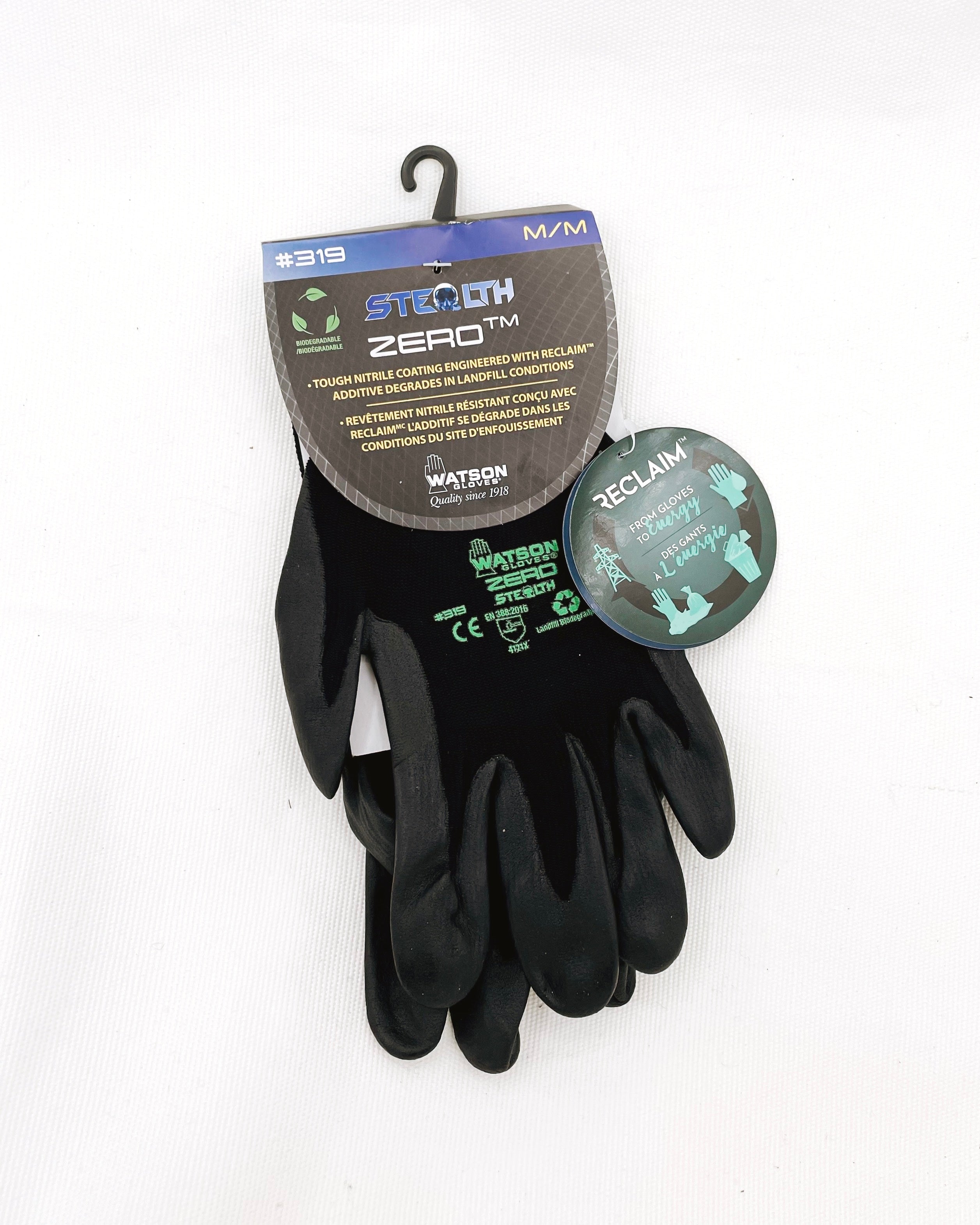 Flat lay image of Biodegradable Men’s Garden Gloves Stealth Zero by Watson Gloves on white background. There is one pair of black gloves in this image. One is turned face up and one is turned face down. The gloves are black with a padded area for the palm. The Watson Gloves logo is in green font on the backside of the glove along with descriptive text.